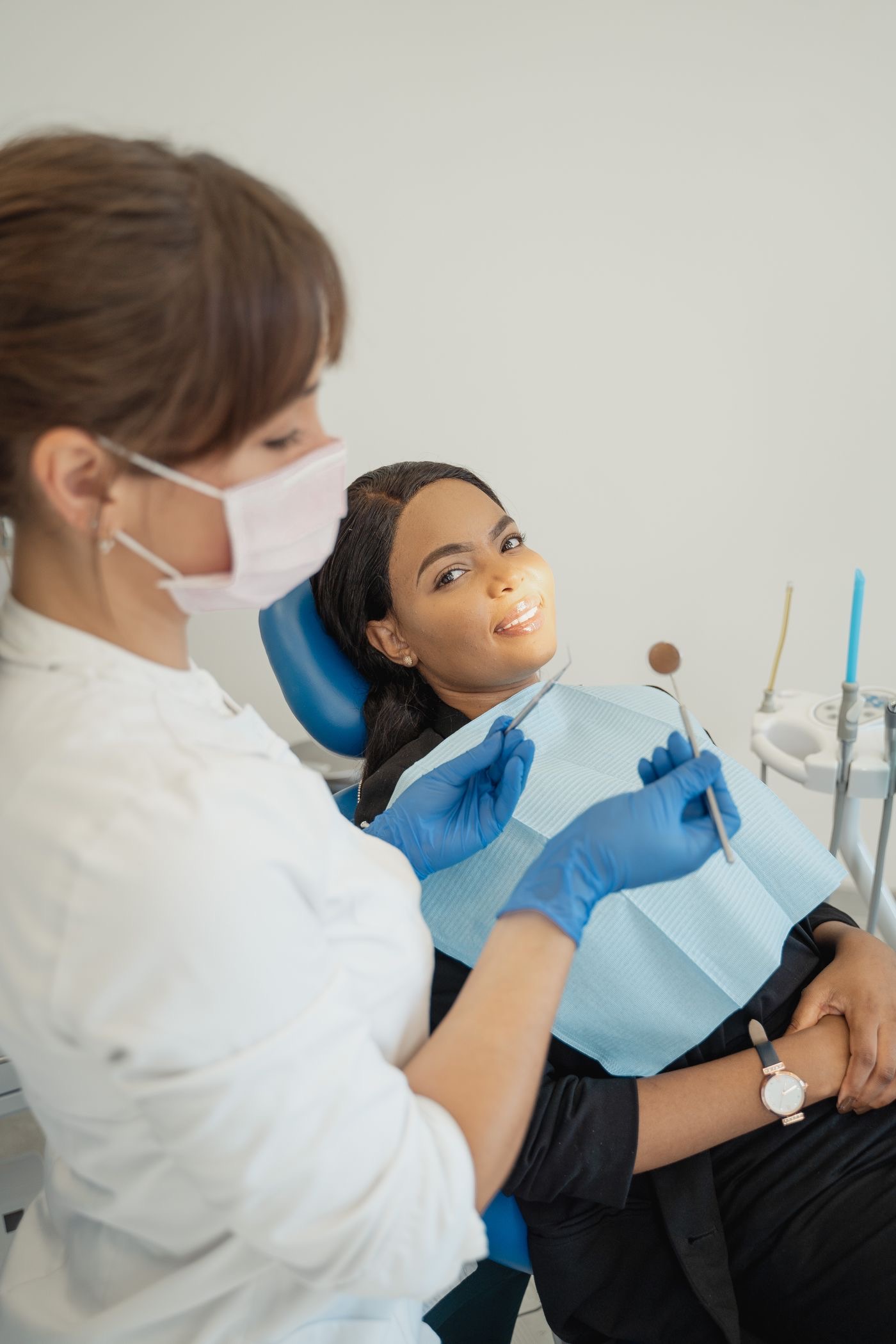 Dentista atendendo paciente sorrindo